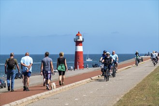 North Sea dyke near Westkapelle, Westkapelle Laag lighthouse, cyclists on the Zeeuwse Wind Route