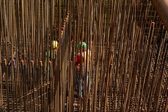 Construction site, reinforced concrete construction site, workers erect a mesh of reinforcing bars,