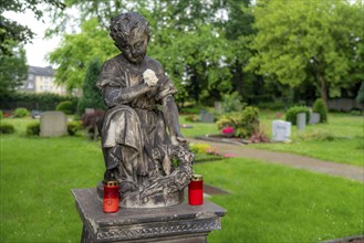 Figure in a cemetery, old gravestone, with flower and grave light, North Rhine-Westphalia, Germany,