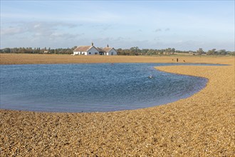 Lagoon of water used by swimmers on beach at Shingle Street, Suffolk, England, UK