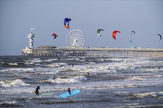 The pier and Ferris wheel at Scheveningen beach, strong swell, windsurfers, kitesurfers, surfers,