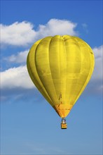 A yellow hot air balloon rises into the air as part of the aviation festival on the Rossfeld in