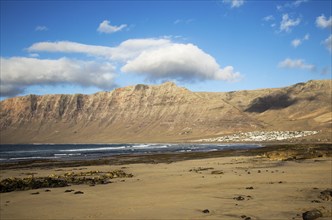 Late afternoon light on beach and cliffs La Caleta de Famara, Lanzarote, Canary islands, Spain,