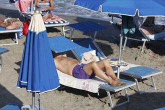 Man on a sun lounger, sunbathing on the beach of Diano Marina, Italy, 14/08/2024, Diano Marina,