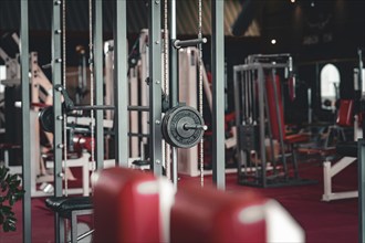 A modern fitness studio with various exercise machines and dumbbells, designed in red and steel,