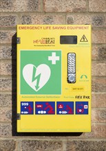 Automated External Defibrillator emergency life saving equipment mounted on wall, Community