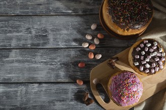 Homemade glazed and decorated easter pies with chocolate eggs and rabbits on a gray wooden