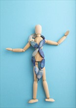 Wooden mannequin with blue agate beads on blue pastel background. copy space, isolated, luxury, bad