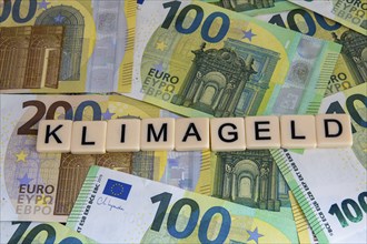 Symbolic image of climate money: Letters on euro notes display the word climate money