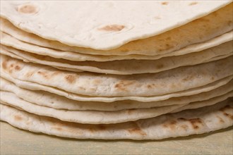 A stack of Mexican tortillas, on a gray table, top view, close-up, no people