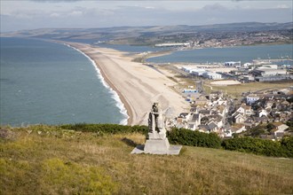 Chesil beach tombolo, with quarrying monument in the foreground Chiswell, Isle of Portland, Dorset,