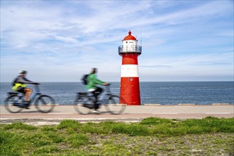 North Sea dyke near Westkapelle, Westkapelle Laag lighthouse, cyclists on the Zeeuwse Wind Route