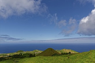 Sweeping views over green volcanic hills that gently fade into the sea under a big sky, Caldeira