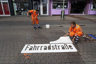 Application of road markings for a cycle lane, Rüttenscheider Straße in Essen, in the shopping and