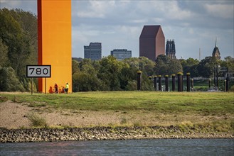 The sculpture Rhine Orange at the mouth of the Ruhr into the Rhine, skyline of the city centre of