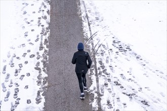 Winter in the city, cleared riverside path on the Main, jogger, Frankfurt, Hesse, Germany, Europe