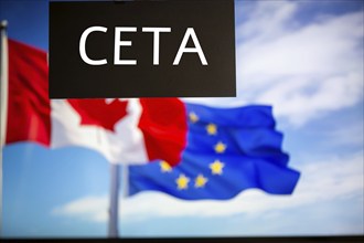 Sign reading CETA in front of the flags of Canada and the European Union. The abbreviation CETA