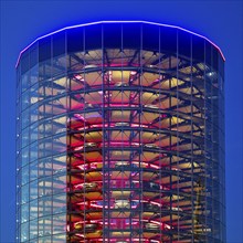 An illuminated car tower with new cars for delivery in the evening, Autostadt, Volkswagen AG,