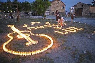 Castilian boy lights candles, Conciertos de las Velas festival of lights, Pedraza, Segovia