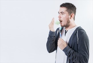 Person holding brush with bad breath problem isolated. Man holding brush checking bad breath