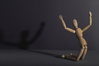 Wooden mannequin in imploration, praying position on gray background. religion, despair concept.