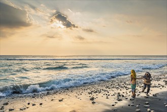 Muslim woman in the evening sun at Mangsit beach in Sengiggi, Islam, religion, headscarf, travel,