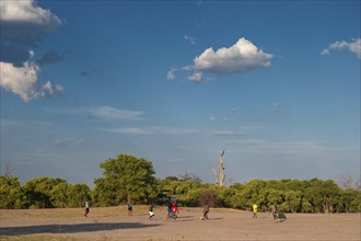 Men play football on a football pitch during their free time, sports, in the evening heat at Savuti