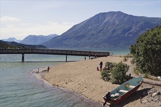 Boat, footbridge on a sandy beach, Bennett Lake, Yukon Territory, Canada, North America