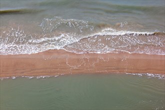 Aerial view at sea waves rolling in to a sand beach, Skagen, Denmark, Europe