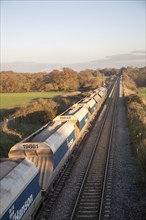 Open waggons of freight train on the West Coast mainline at Woodborough, Wiltshire, England, UK