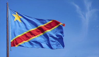 The flag of the Democratic Republic of the Congo flutters in the wind, isolated against a blue sky