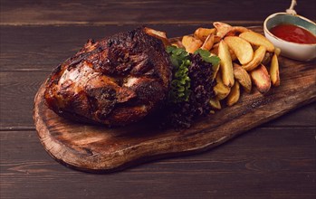 Pork knuckle, in soy-honey sauce, with fried potatoes, on a wooden chopping board, homemade, no