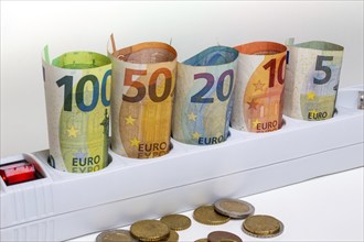 Symbolic image of electricity costs: Multiple socket outlet with banknotes