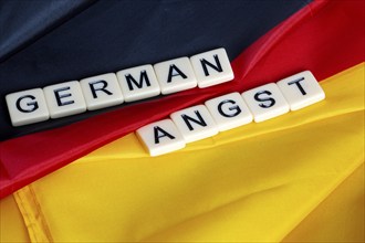 Symbolic image of German Angst: letter cube on a German flag