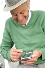 A senior citizen talking on his smartphone, mobile phone, mobile phone, 65 years old, studio