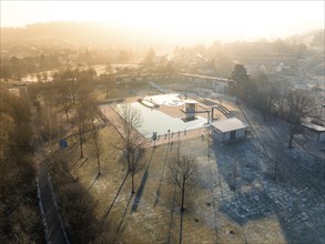 Winter morning with frosty trees and long shadows in a swimming pool, ENCW outdoor pool Calw,