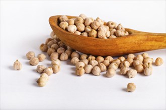 Pile of chickpeas in a wooden spoon isolated on white background