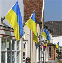 Support for Ukraine, Ukrainian national flags flying outside shops, Saxmundham, Suffolk, England,