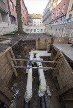 Construction site of a district heating house connection, pipes, insulated, are laid from a central