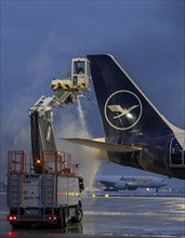 Winter at Frankfurt Main Airport, FRA, Lufthansa aircraft being de-iced by de-icing vehicles,