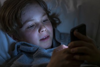 A boy plays computer games on a mobile phone, smartphone