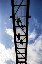 Lattice walkway, people walk over a walkway at a height of a good 15 metres, made of steel lattice,