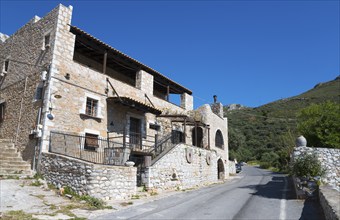 A traditional stone house on a village street with Mediterranean flair and blue sky in the