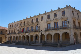 Historic building with several balconies and flags in front of a blue sky, Ayuntamiento, Town Hall,