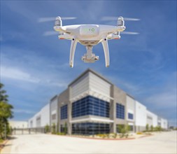 Unmanned aircraft system (UAS) quadcopter drone in the air near corporate building