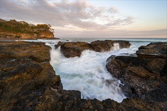 Waves washing over rocks by the sea, long exposure, coastal landscape at sunset, Playa Cocalito,