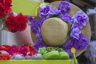 Straw hat decorated with artificial flowers in red and purple, Ile de Brehat, Brittany, France,