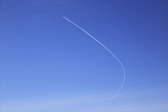 Contrail of airplane outlined in clear blue sky over Suffolk, England, UK