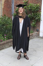 Full length portrait smiling young woman graduating, Goldsmiths College, University of London,