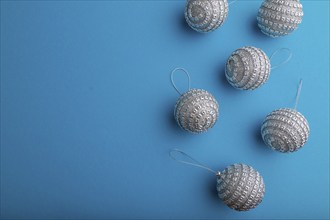 Christmas or New Year composition. Decorations, silver balls, on a blue paper background. Top view,